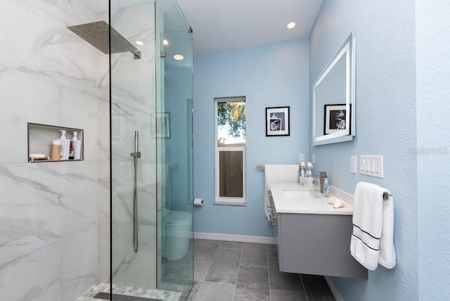 bathroom with a tile shower and vanity