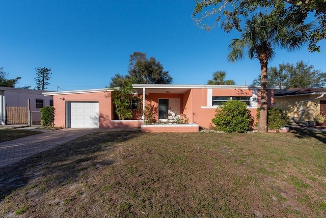 ranch-style house featuring a garage and a front lawn