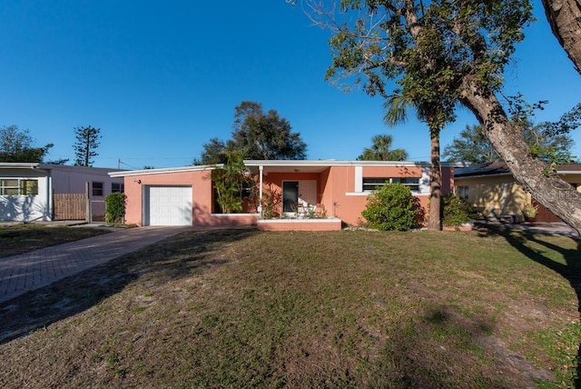 ranch-style home featuring a garage and a front lawn