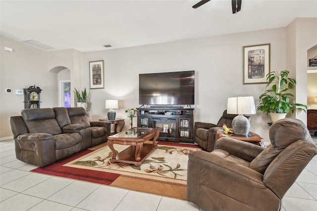 living room with ceiling fan, a fireplace, and light tile patterned floors