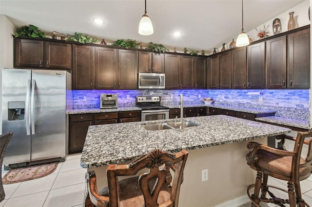 kitchen featuring sink, stainless steel appliances, decorative light fixtures, and dark brown cabinetry