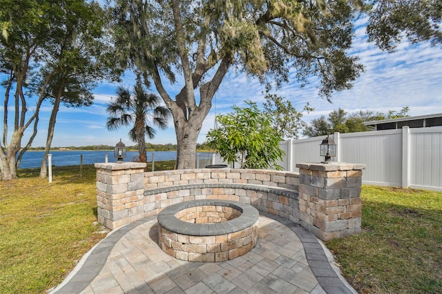 view of patio with a fire pit and a water view