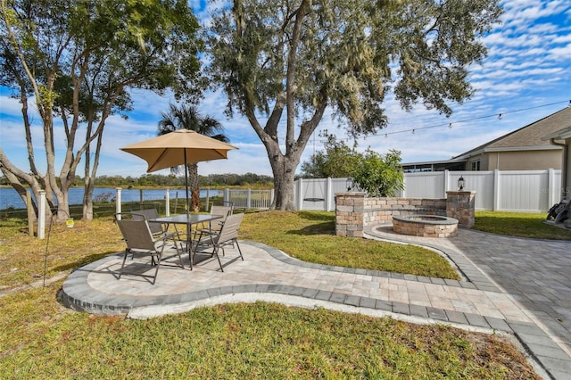 view of yard featuring a patio, a fire pit, and a water view