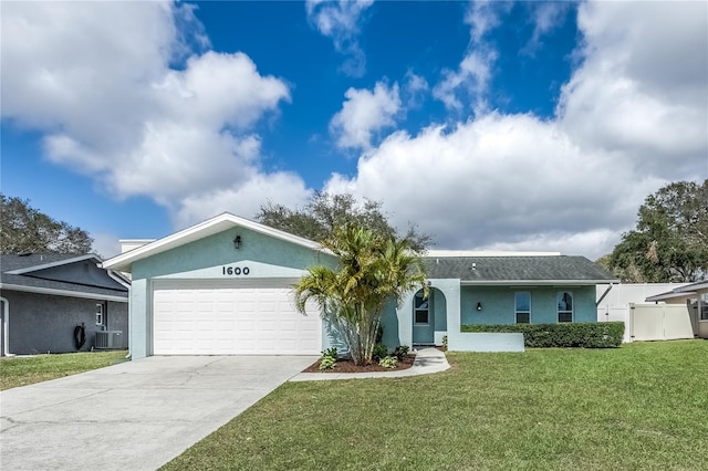 ranch-style house featuring concrete driveway, a front lawn, an attached garage, and central air condition unit