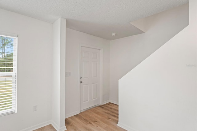 foyer entrance featuring light hardwood / wood-style flooring and a textured ceiling