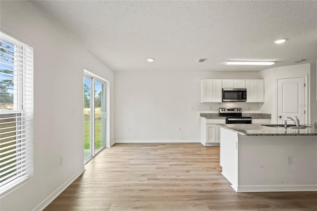 kitchen featuring stone counters, sink, a textured ceiling, white cabinets, and appliances with stainless steel finishes