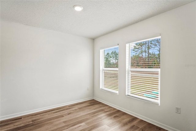 empty room featuring a textured ceiling and light wood-type flooring