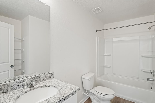 full bathroom featuring vanity, a textured ceiling, shower / tub combination, hardwood / wood-style floors, and toilet