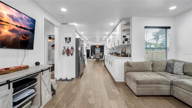 living room featuring light hardwood / wood-style flooring and ceiling fan