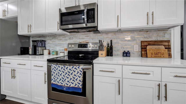 kitchen with stainless steel appliances, white cabinetry, and light stone countertops