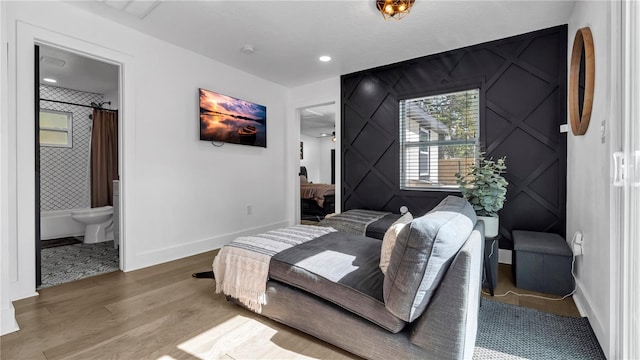 bedroom with wood-type flooring and ensuite bath