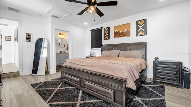 bedroom featuring ceiling fan, ensuite bathroom, and light wood-type flooring