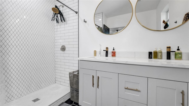 bathroom featuring a tile shower and vanity