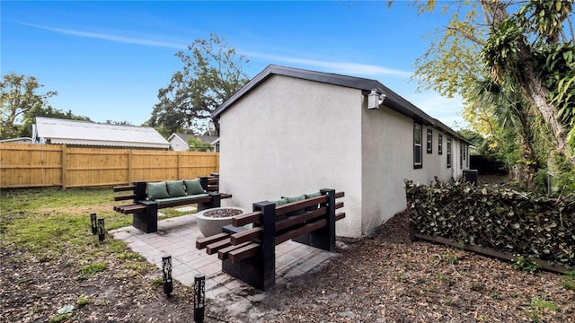 rear view of house with an outdoor fire pit and a patio