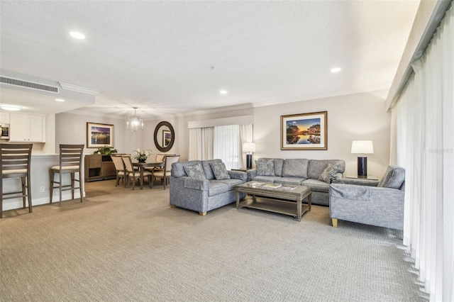 carpeted living room featuring ornamental molding, a textured ceiling, and a notable chandelier