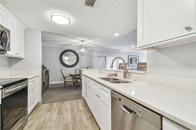 kitchen with pendant lighting, sink, a textured ceiling, white cabinetry, and stainless steel appliances