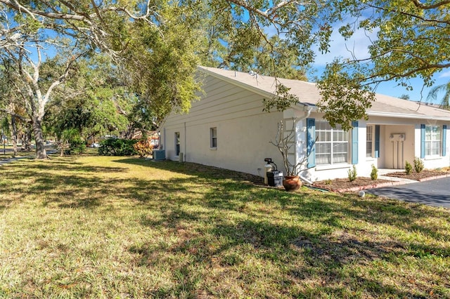 view of side of home with central air condition unit and a yard