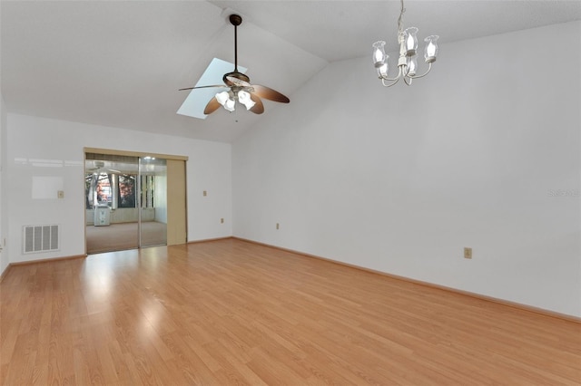 unfurnished living room with ceiling fan with notable chandelier, lofted ceiling, and light hardwood / wood-style flooring