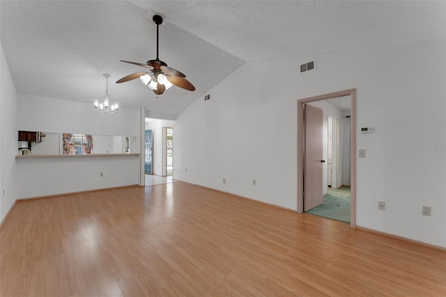 unfurnished living room featuring a textured ceiling, ceiling fan with notable chandelier, light hardwood / wood-style floors, and vaulted ceiling