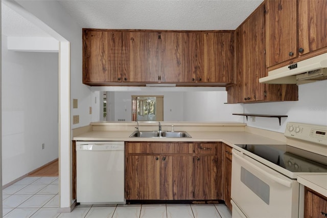 kitchen featuring a textured ceiling, sink, light tile patterned flooring, and white appliances