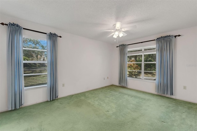 carpeted empty room featuring a textured ceiling and ceiling fan