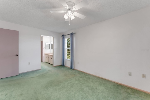 carpeted empty room featuring ceiling fan and a textured ceiling