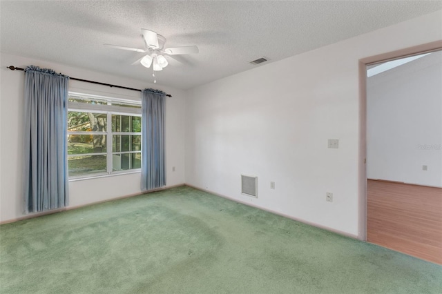 carpeted empty room featuring ceiling fan and a textured ceiling