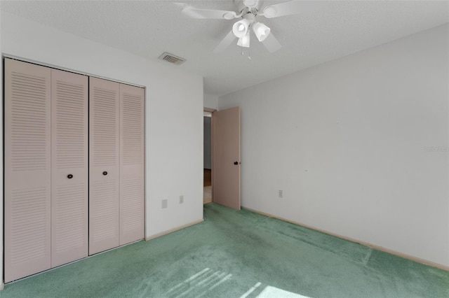 unfurnished bedroom with carpet flooring, a textured ceiling, a closet, and ceiling fan