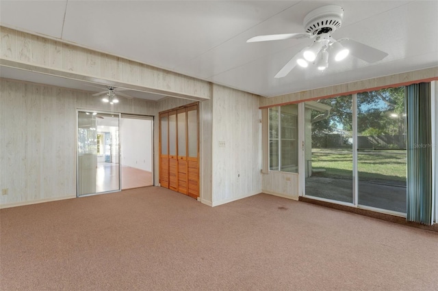 carpeted spare room featuring ceiling fan and a healthy amount of sunlight