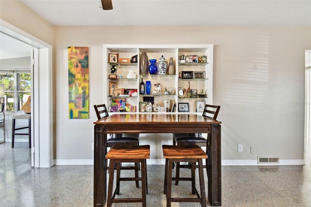 dining area with speckled floor, visible vents, and baseboards