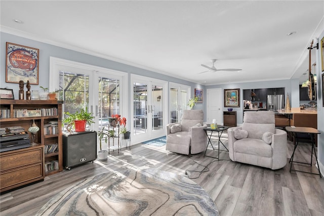 living room with ceiling fan, hardwood / wood-style floors, ornamental molding, and french doors