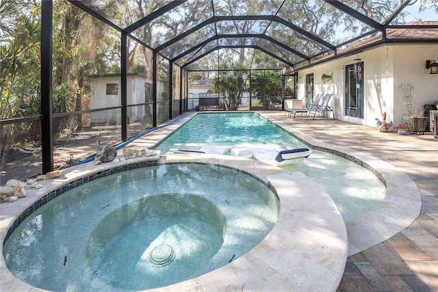 view of pool featuring an in ground hot tub, a patio area, a lanai, and a storage shed