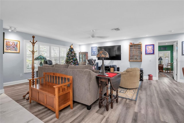 living room featuring ceiling fan and light hardwood / wood-style flooring