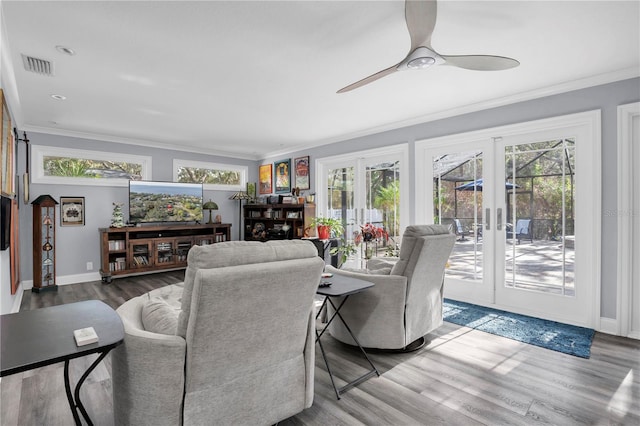 living room with hardwood / wood-style flooring, ceiling fan, crown molding, and french doors