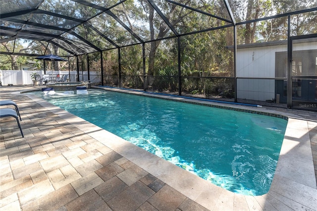 view of swimming pool featuring glass enclosure and a patio area