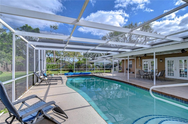 view of swimming pool with a lanai, ceiling fan, french doors, and a patio