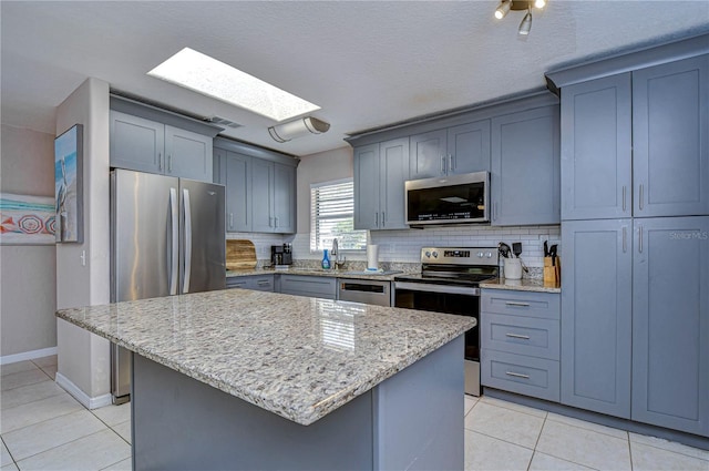 kitchen featuring backsplash, a kitchen island, stainless steel appliances, and a skylight