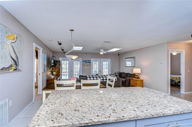 kitchen featuring ceiling fan, french doors, light tile patterned flooring, and decorative light fixtures