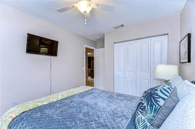 bedroom with carpet, a textured ceiling, a closet, and ceiling fan