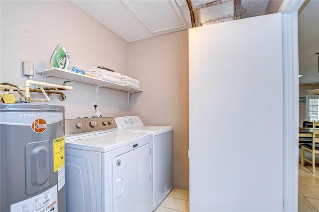 laundry room featuring washing machine and dryer, water heater, and light tile patterned flooring