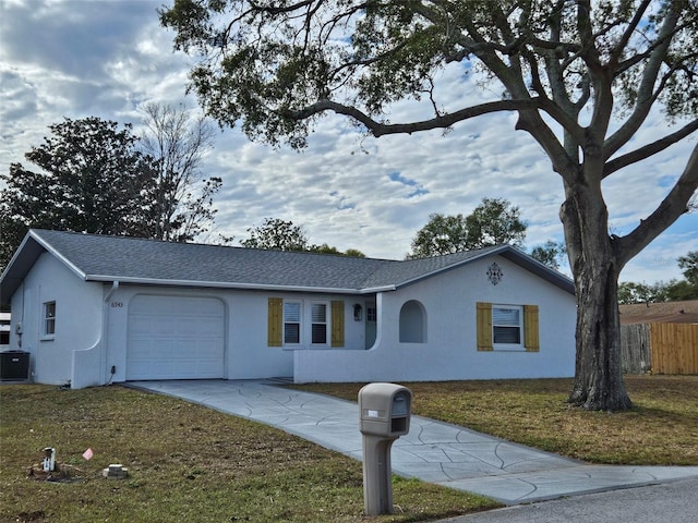 ranch-style house featuring a garage, central air condition unit, and a front lawn