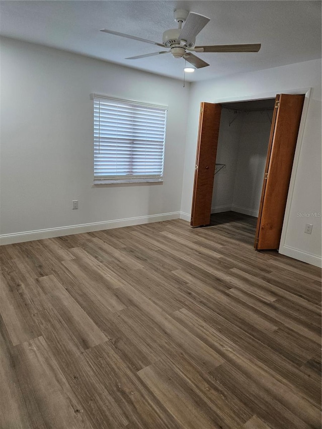 unfurnished bedroom with ceiling fan, a closet, and hardwood / wood-style floors