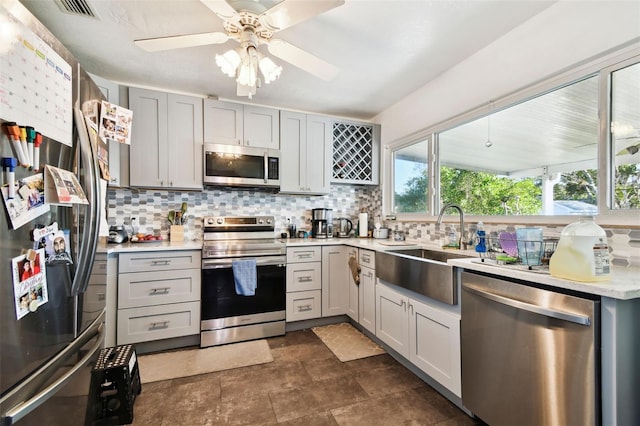 kitchen with gray cabinetry, ceiling fan, and appliances with stainless steel finishes