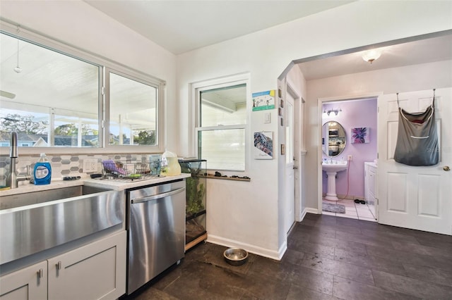 kitchen featuring tasteful backsplash, stainless steel dishwasher, and sink