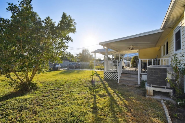 view of yard featuring central AC unit and a wooden deck