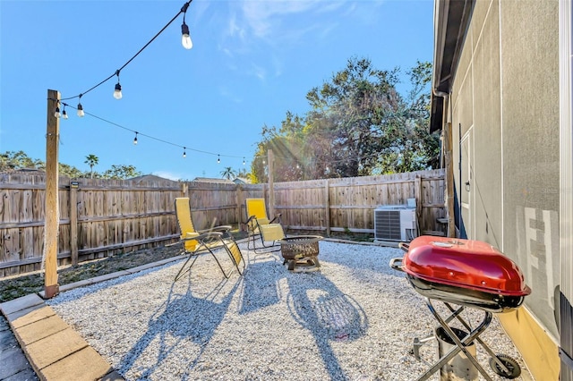 view of patio / terrace featuring grilling area, central AC unit, and a fire pit