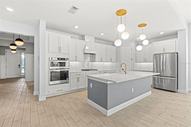 kitchen with backsplash, white cabinetry, decorative light fixtures, and appliances with stainless steel finishes