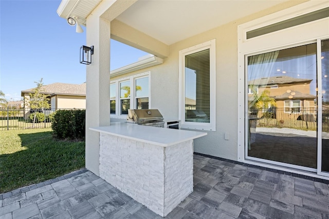 view of patio / terrace with fence, exterior kitchen, and area for grilling