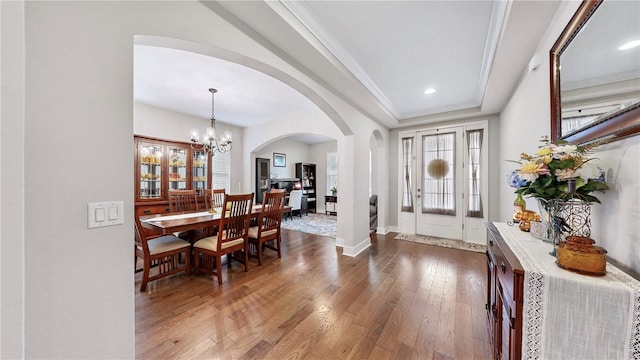 foyer entrance featuring a healthy amount of sunlight, a chandelier, hardwood / wood-style flooring, and a tray ceiling