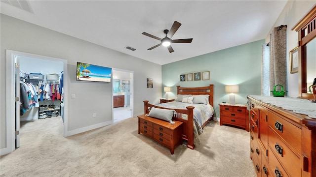 carpeted bedroom with a closet, connected bathroom, ceiling fan, and a spacious closet